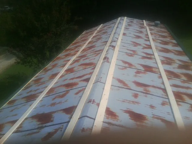 Rusted metal roof panels with new wood purlins before replacement — Storm Damage Roof Repair in Jefferson City by Roofing Brothers