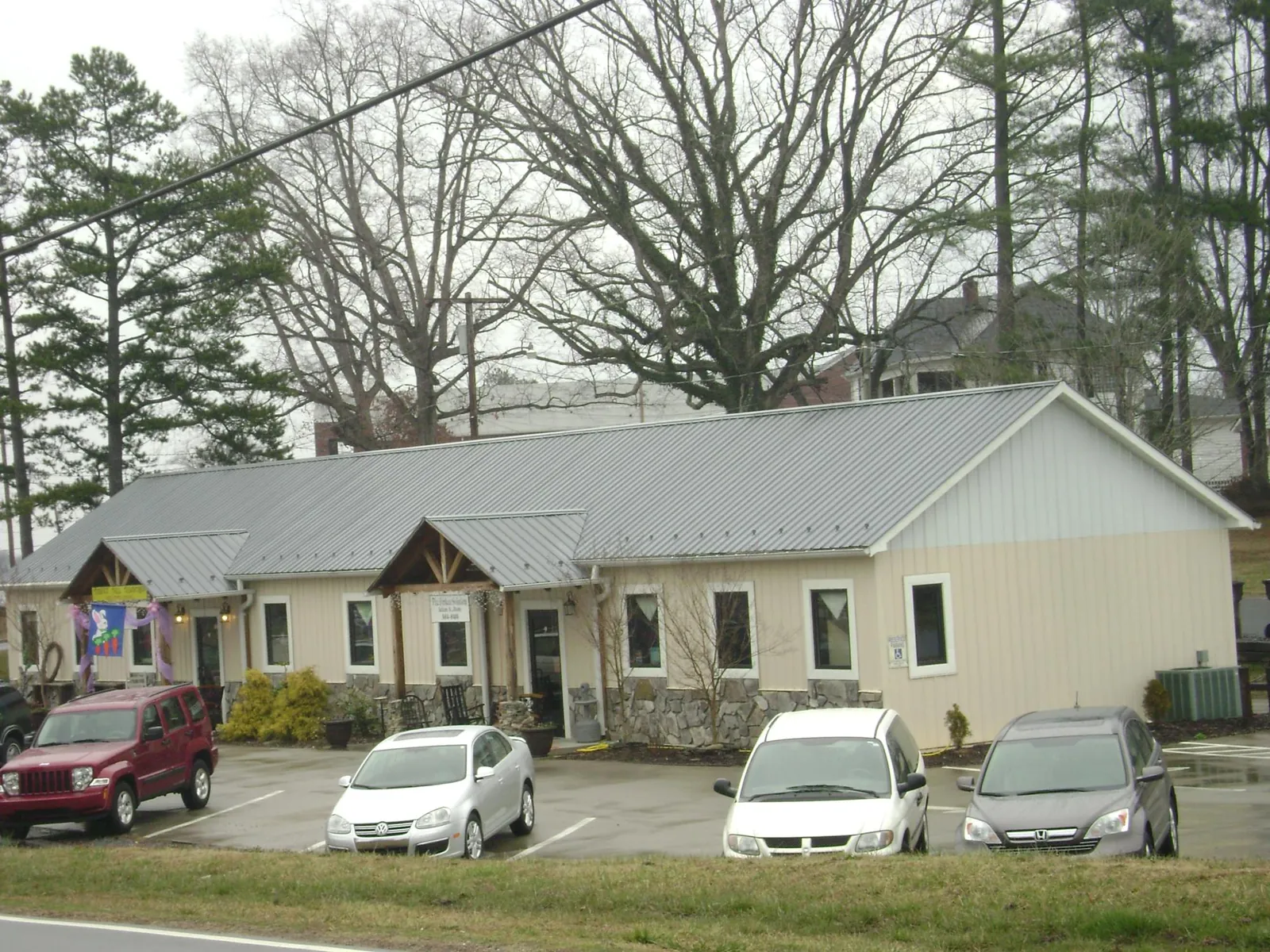 Gray metal roof with timber entry brackets on a small commercial building in Jefferson City