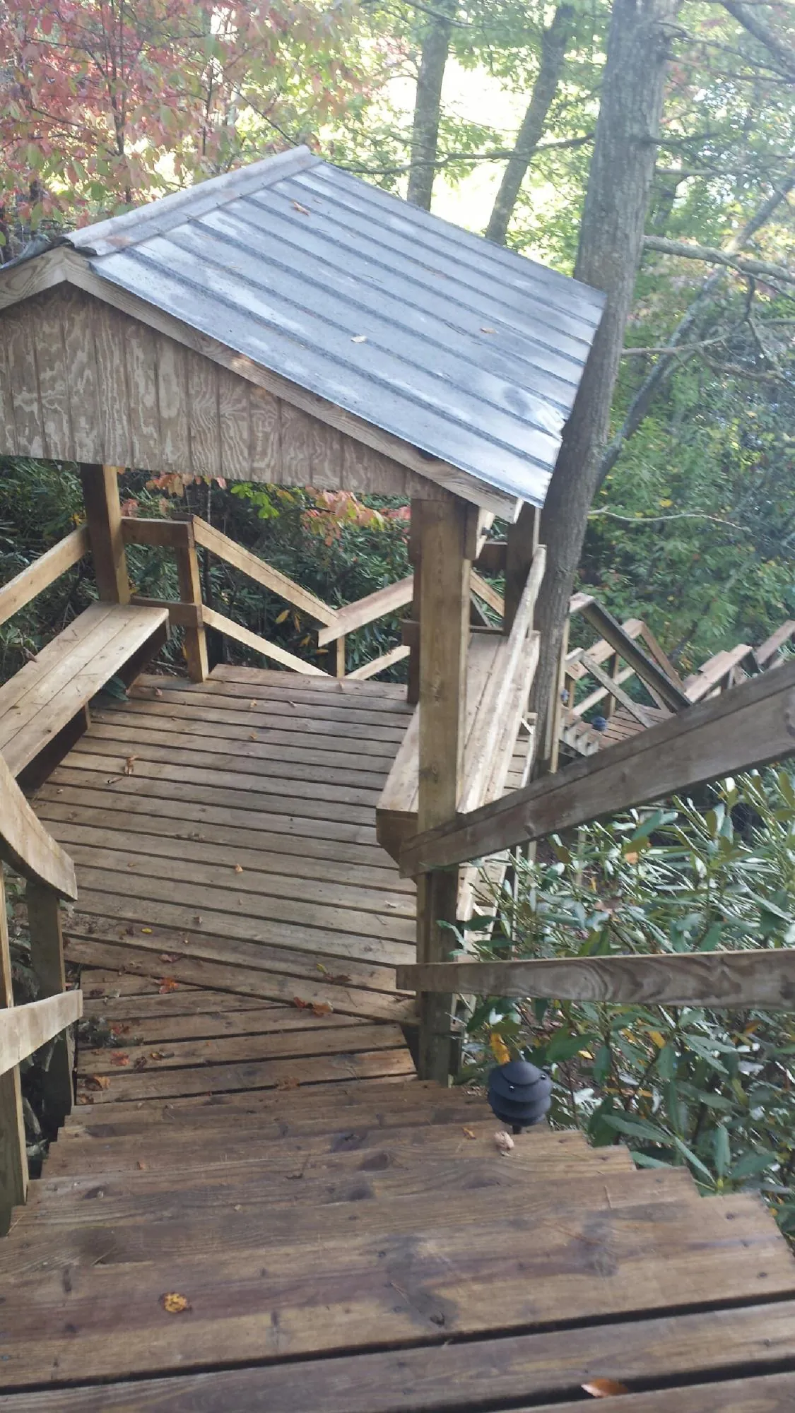 Metal roofed shelter over wooden steps on a wooded walkway — Skylight Repair & Installation work by our crew in Jefferson City