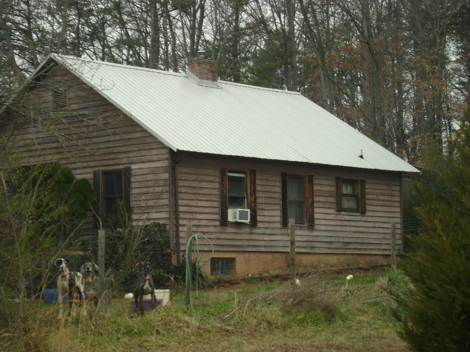 White metal roof on an old wood sided farmhouse, from a Metal Roof Installation job in Jefferson City